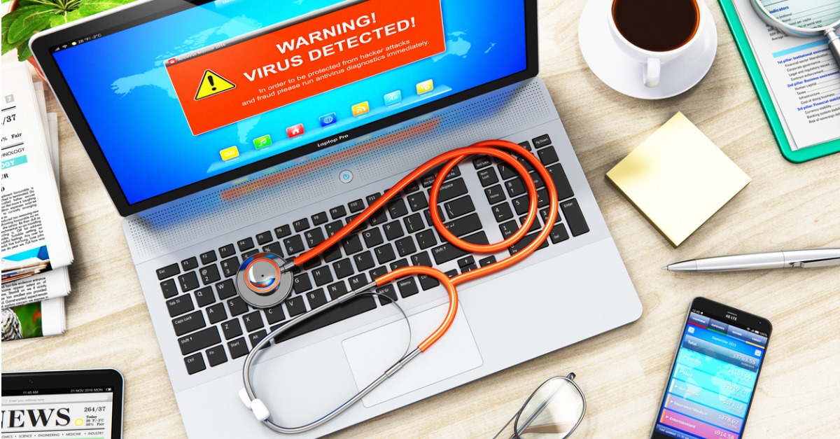 Laptop with virus attack warning message on screen and stethoscope