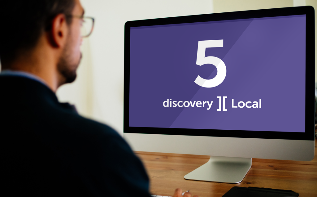 Man looking at computer screen with discovery Local logo